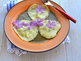 Ravioli ai fiori di malva ripieni rucola e ricotta su pesto di crescione