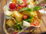 Insalata di cachi persimon, ravanelli, cuori di lattuga nel cestino di pane