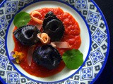 Ravioli al nero di seppia farciti con pesce spada su crema di pomodoro