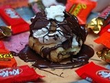 Cream puffs stuffed with whipped cream and peanut butter cups and drizzled with chocolate