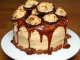 Triple layer chocolate cake coated in caramel butter cream, topped with salted caramel and decorated with chocolate dipped coconut macaroons