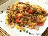 Mezze penne bicolori con calamaretti nostrani  piselli e pomodorini